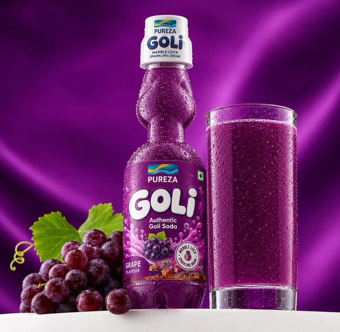 A marble-lock bottle of PUREZA Goli grape soda beside a filled glass and a bunch of grapes