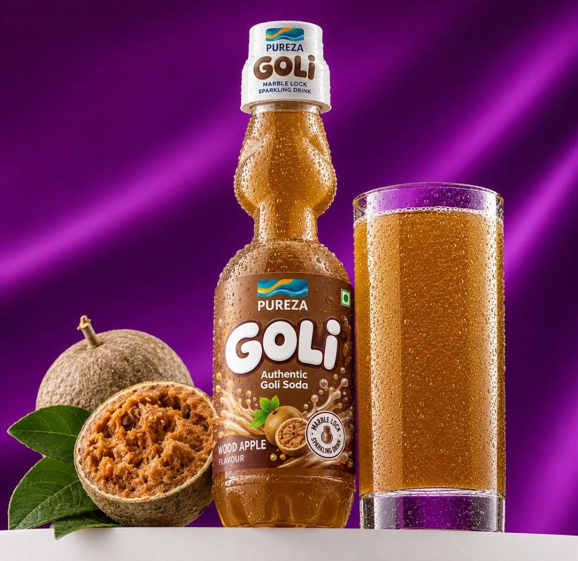 A marble-lock bottle of PUREZA Goli wood apple soda beside a filled glass and a halved wood apple